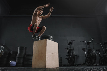 Athlete doing box jump exercise at the crossfit gym
