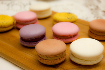 multicolored french macaroon cake on a wooden board