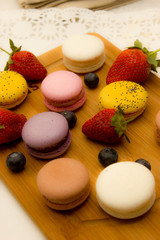 multicolored french macaroon cake on a wooden board