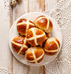 Hot cross buns, freshly baked hot cross buns on a white plate on a wooden table, top view....
