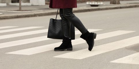 close up of woman legs walking on crosswalk