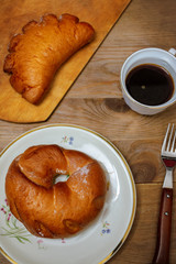 Sweet donut and bagel on a plate on wooden table