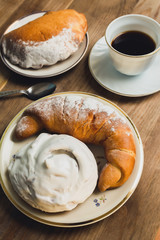 Sweet donut and bagel on a plate on wooden table