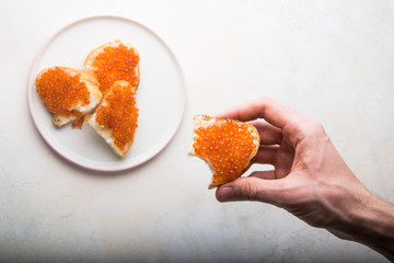 red caviar in hand