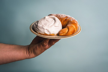 Sweet donut and bagel on a plate in a man's hand