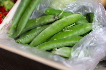 A handful of green bean pods in a plastic bag