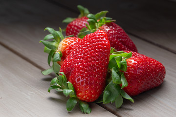 a pile of red ripe Strawberries on a wooden table