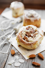 Sinnabon buns. Sinabon rolls with cream cheese and cream, chocolate and almond nuts