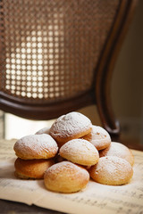 Homemade profiteroles on the music sheet with notes. Profiteroles (choux à la crème) - French choux pastry balls filled with custard