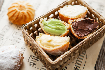 Homemade profiteroles on the music sheet with notes. Profiteroles (choux à la crème) - French choux pastry balls filled with custard or cottage cheese