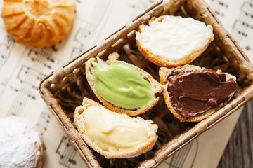 Homemade profiteroles on the music sheet with notes. Profiteroles (choux à la crème) - French choux pastry balls filled with custard or cottage cheese