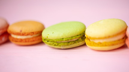 Multicolored macaroons on pink background.