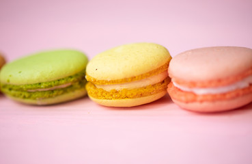 Multicolored macaroons on pink background.