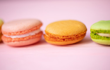 Multicolored macaroons on pink background.