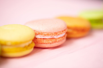 Multicolored macaroons on pink background.