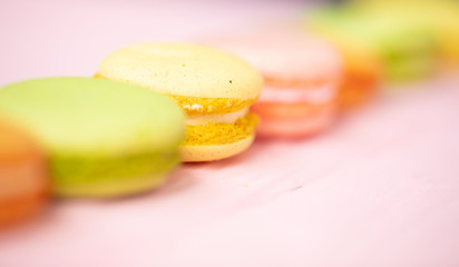 Multicolored macaroons on pink background.