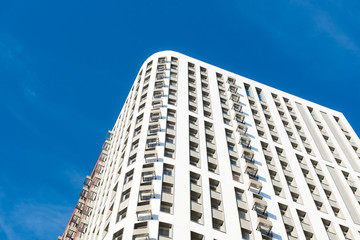 Obraz premium Modern new multi-storey residential building against the blue sky. business card concept