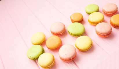 Multicolored macaroons on pink background.