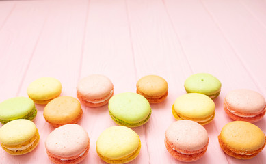 Multicolored macaroons on pink background.