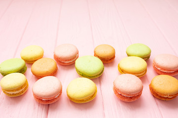 Multicolored macaroons on pink background.
