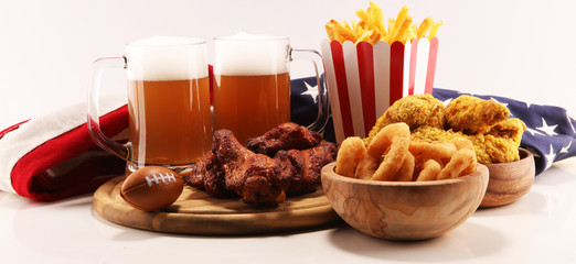 chicken wings, fries and onion rings for football on a table. Great for Bowl Game