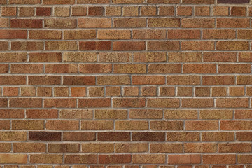 Vintage red brown multi-colored textured brick wall background in American bond brickwork pattern with shades of tan, salmon and pink (angle view)