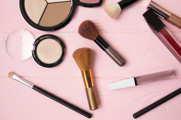 Makeup cosmetics, brushes and other essentials on white background. Top view, flat lay. Multicolored beauty tools and products collection, lipsticks, eyeshadow, mascara and more