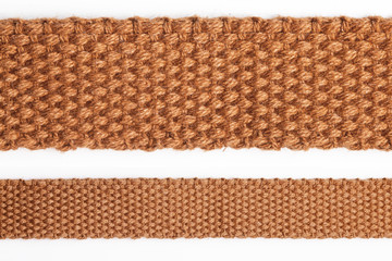 Brown linen textile strap isolated on white. Fiber fabric retro belt texture.
