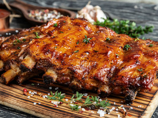 grilled pork ribs with sauce on a cutting board , spice, marinade, closeup