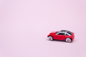 Toy red car on a pink background, gentle concept.