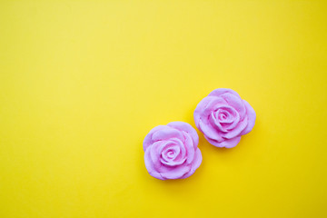 Polymer clay flowers, bright yellow background. Copy space