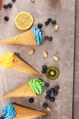 Vanilla frozen yogurt or colorful soft ice cream in waffle cone.