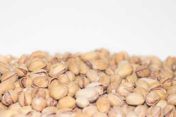 Roasted and salted pistachios in shell. Partial focus. Food background.