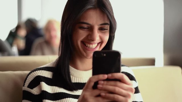 Smiling young woman make video in cafe. She shooting cameraman and smile
