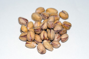 many salted pistachio nuts close up isolated on white background