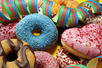 assorted donuts with chocolate frosted, pink glazed and sprinkles donuts