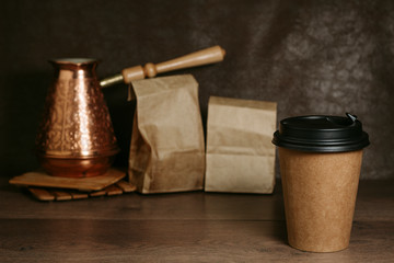 Paper cup with coffee on a wooden surface