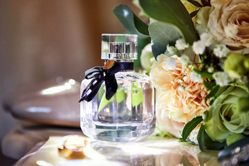 bridal accessories such as shoes, bouquet , ring and perfume lie on a table