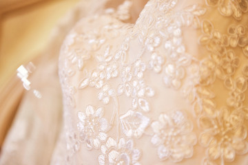 beautiful wedding dress hanging in the room, woman getting ready before  ceremony