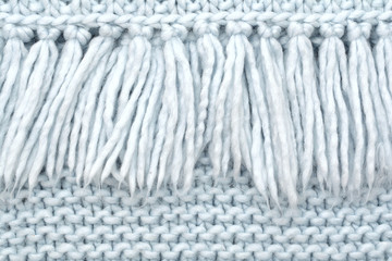 The texture of knitted wool fabric of purl loops with fringe.