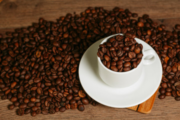 Cup with coffee beans on a wooden surface