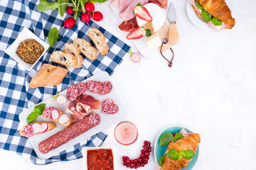 Appetizers table with italian antipasti snacks and wine in glasses. Salami and bruschetta with fresh vegetables on a white background. Free space for text. Traditional snacks for wine.