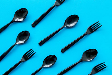 Plastic flatware for eco concept on blue background top view pattern