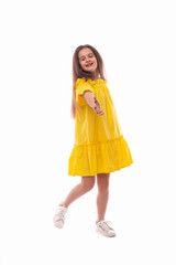 Studio shot of a little smiling girl wearing yellow sundress  on a white background.