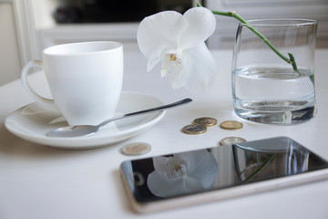 Flat lay financial planning, hand doing calculation with mobile phone and objects on yellow table top.