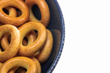 dry bread-ring in the blue bowl on the white background