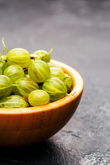 Image of gooseberry berries in wooden cup.