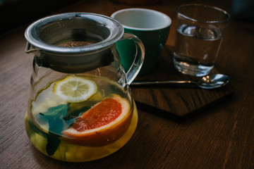 Ginger tea with mint and lemon and grapefruit. Herbal healthy drink in the teapot in local cafe