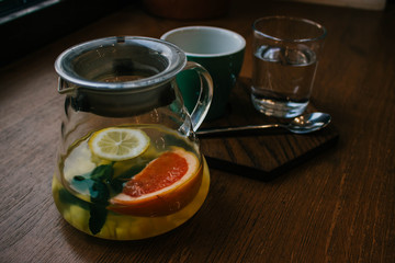 Ginger tea with mint and lemon and grapefruit. Herbal healthy drink in the teapot in local cafe