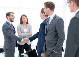 Manager looks at the handshake of business partners